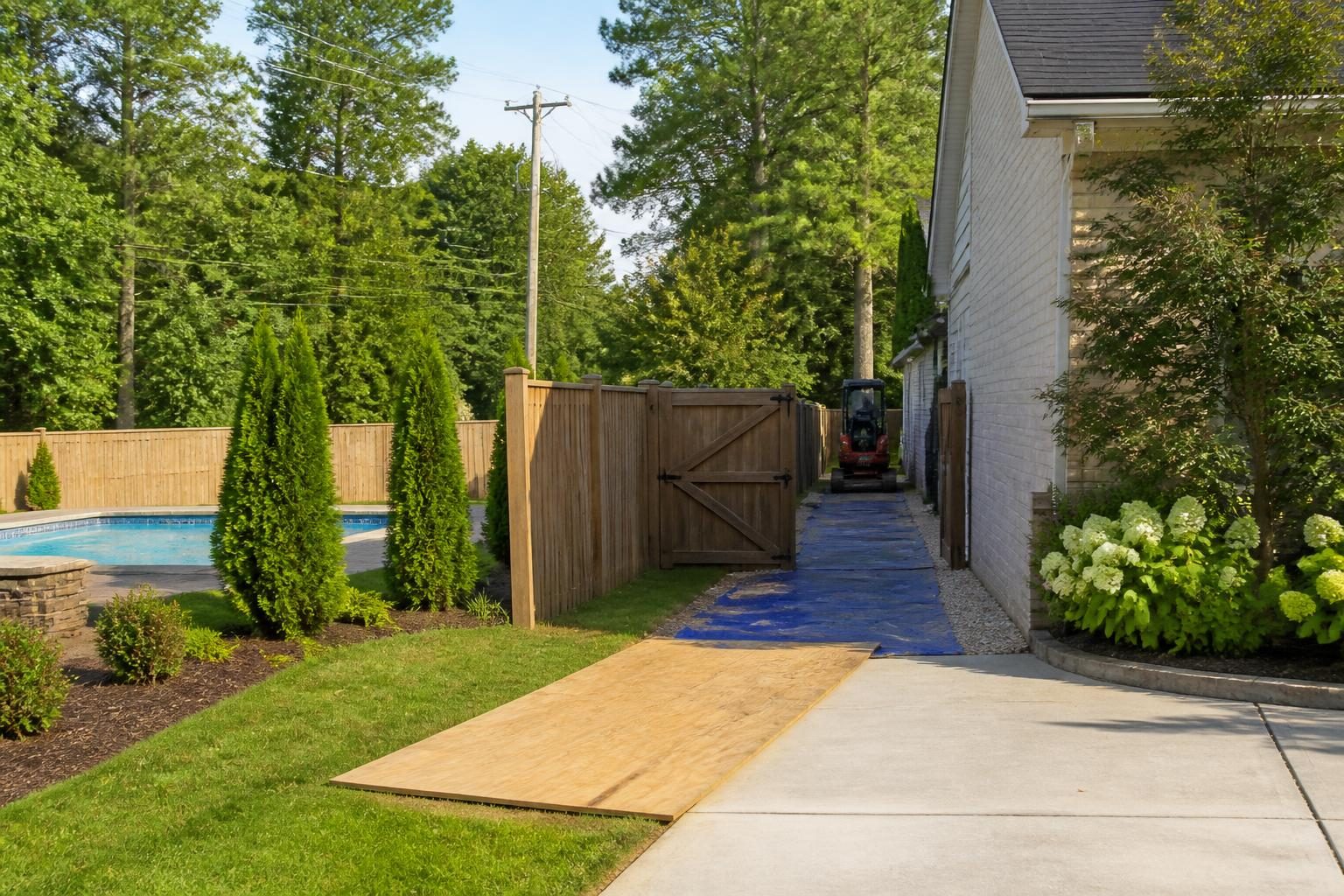 Backyard access for pool construction shown through a measured side-yard route, gate, driveway, trees, and protected landscaping in North Carolina